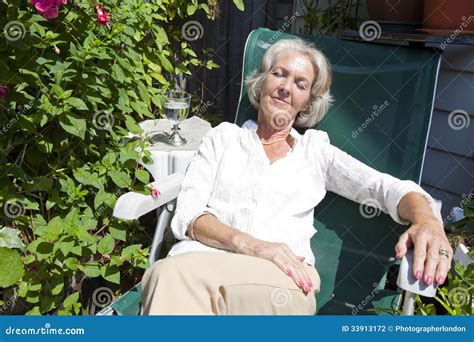 Senior Woman Relaxing On Lounge Chair In Garden Stock Photo Image Of