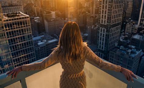 Rich Woman Enjoy The Sunset Standing On The Balcony At Luxury