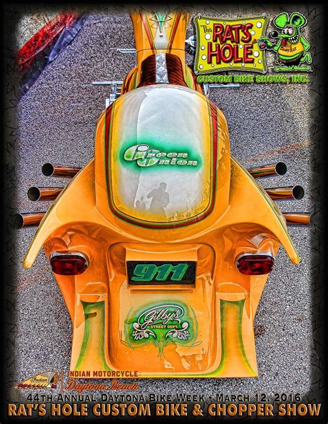 The Front End Of An Orange Motorcycle With Green And Yellow Lettering
