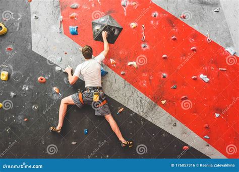 Sportsman Climber Moving Up On Steep Rock Climbing On Artificial Wall