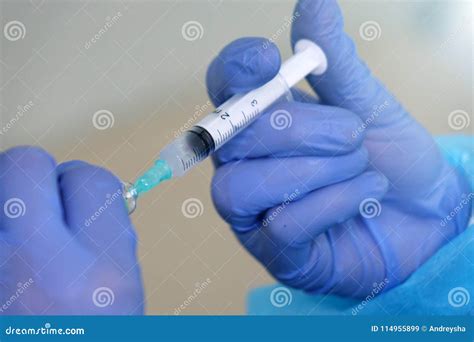 The Nurse Draws The Solution Into The Syringe From The Bottle In The