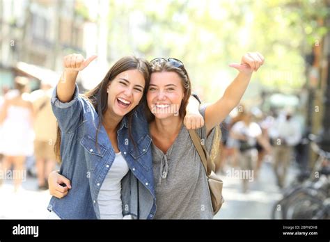 Front View Portrait Of Two Cheerful Friends Laughing Loud Looking At Camera With Thumbs Up Stock