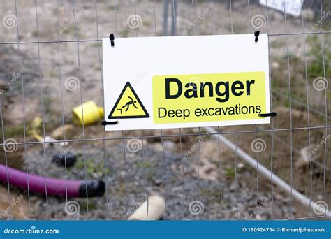 Deep Excavations Danger Sign On Fence With Trench Hole In Background On