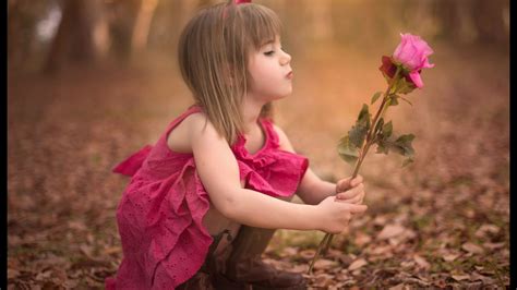 Beautiful Girl Baby With Pink Dress Is Holding Rose On