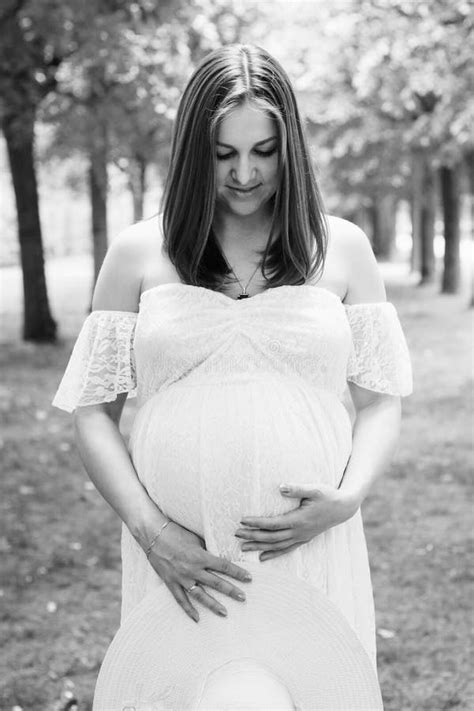 Happy Pregnant Woman Posing Over Green Natural Background Stock Photo