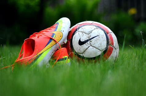 Close Up Photography Of Nike Soccer Cleats And Soccer Ball On Green