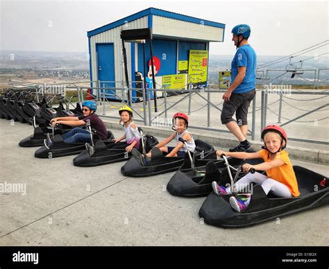 Four Children Prepare To Ride The Skyline Luge In Calgary Canada Stock