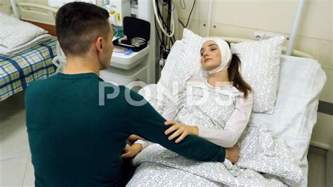Woman Lying On A Hospital Bed Young Man Visiting His Woman In Medical
