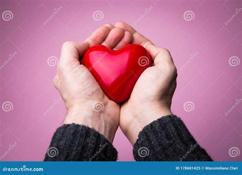 Two Male Hands Holding Heart Genly On Pink Background Saving Love