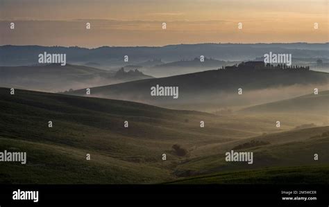 Hilly Landscape With Foggy Atmosphere And Country Estate Sunrise