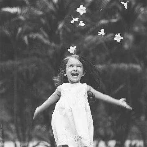 Cheerful Child Trowing Flowers In The Garden Del Colaborador De