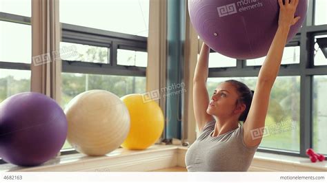 Sporty Brunette Woman Lifting Exercise Ball Stock Video Footage 4682163