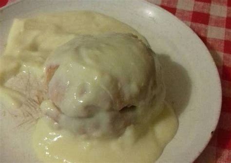 A White Plate Topped With Meat Covered In Gravy On A Red And White