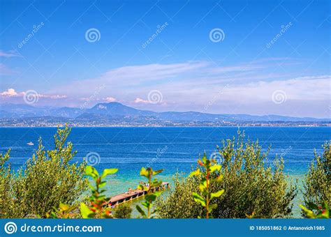 Garda Lake With Blue Azure Turquoise Water And Wooden Pier Dock Stock