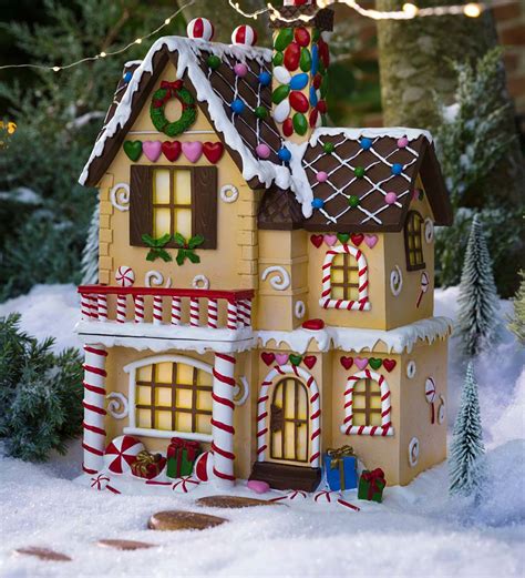 This stunning gingerbread house has unique round windows with white icing trim, diamond shaped windows with white icing trim, and rectangular windows with white icing trim! Lighted Victorian Gingerbread Fairy House | PlowHearth