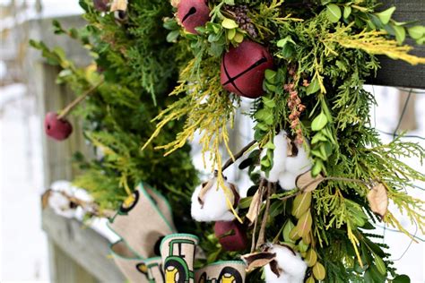 A Wreath With Cotton Balls And Greenery Hanging On A Wooden Sled In The
