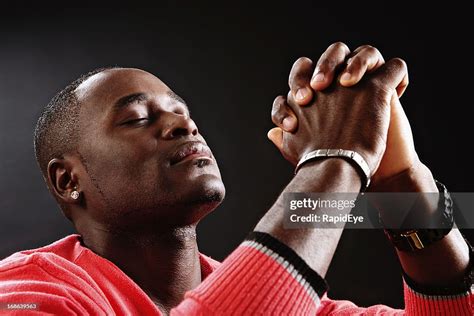 Devout Young Man Prays Fervently Eyes Closed And Hands Clasped High Res