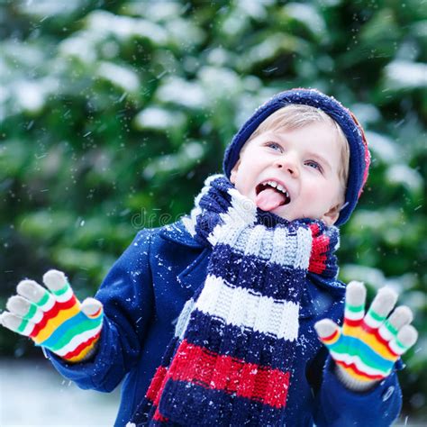 Sad Kid Boy In Colorful Winter Clothes Having Fun With Snow Out Stock