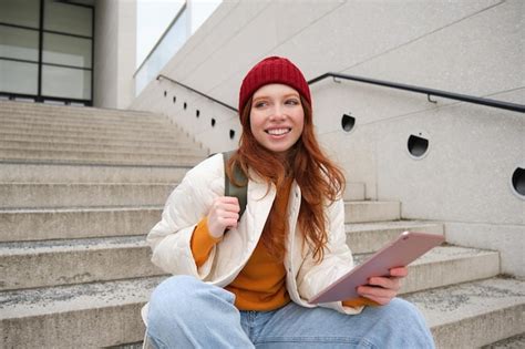 Une Jeune Belle Fille Aux Longs Cheveux Roux Sourit Utilise Une Application Internet Pour Se