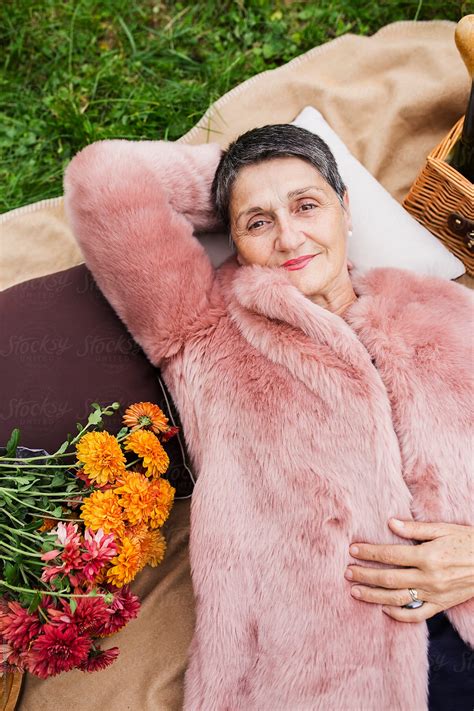 Portrait Of A Beautiful Elderly Woman Lying On Grass Del Colaborador