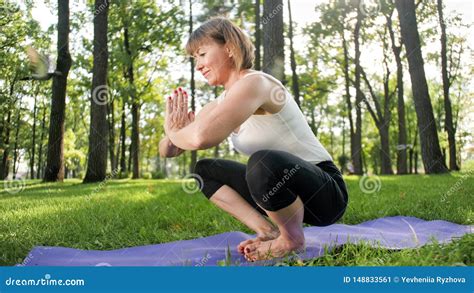 Image Of Smiling Middle Aged Woman In Fitness Clothes Doing Stretching