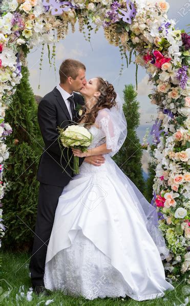 Bride And Groom Kiss Under Flowers Composer Producer