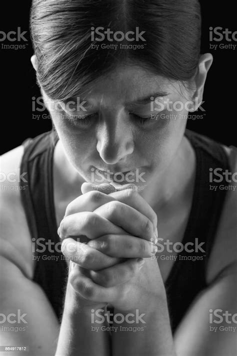 Low Key Portrait Of A Faithful Woman Praying Hands Folded In Worship To