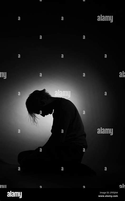 Silhouette Of Depressed And Sad Boy With His Head Down Black And White