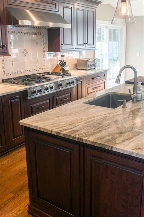 A Large Kitchen With Wooden Cabinets And Marble Counter Tops Along