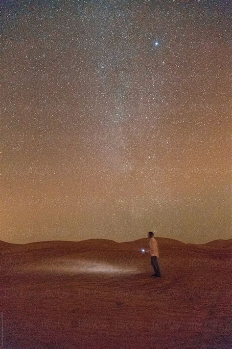 Man Walking Under The Stars On The Empty Quarter Desert By Stocksy