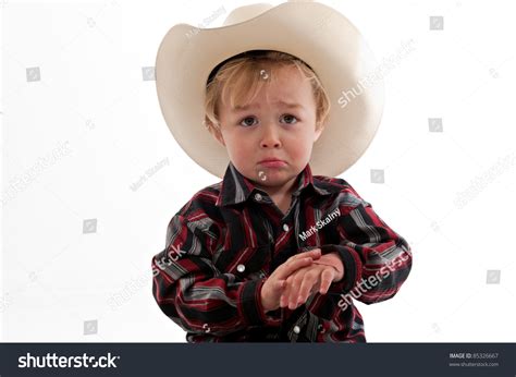 Portrait Of A Sad Little Boy In A Cowboy Hat He Is Frowning And