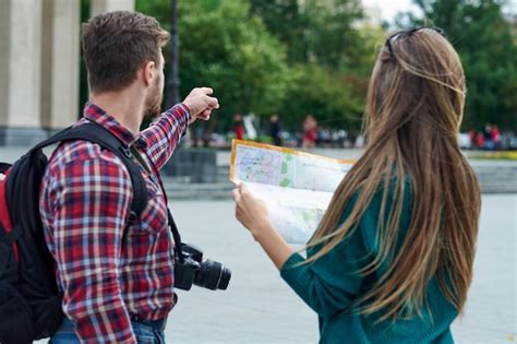 Casal Jovem Com Um Mapa Da Cidade Felizes Turistas Passear A Cidade Com Mapa Foto Premium