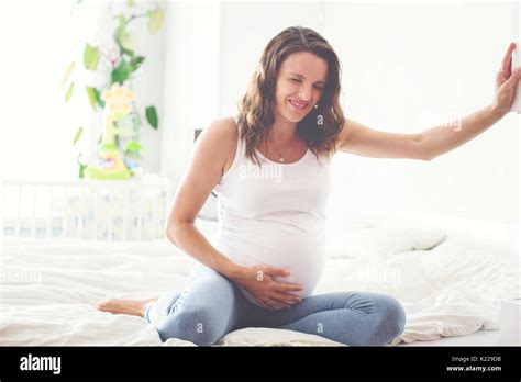 Young Beautiful Pregnant Woman In Pain With Labor Contraction Sitting