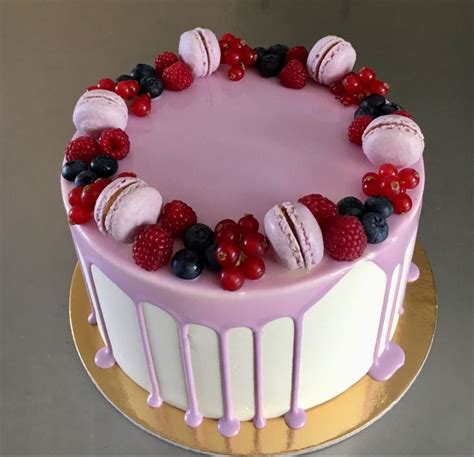 A Cake Decorated With Berries Raspberries And Macaroons
