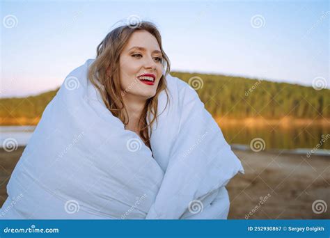 Young Bride Happy Wrapped In A White Blanket Stands On The Shore