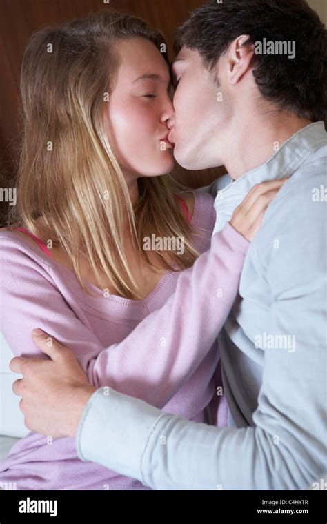 romántica pareja de adolescentes besándose en el sofá en casa juntos fotografía de stock alamy