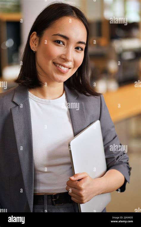 Smiling Young Asian Professional Woman Wearing Suit Vertical Portrait
