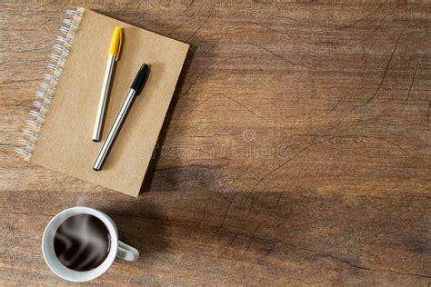 Pens On Notebook And Coffee Cup On Vintage Grunge Wooden Desk Stock