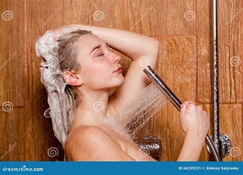 Beautiful Woman Standing At The Shower She Holds In Her Hand
