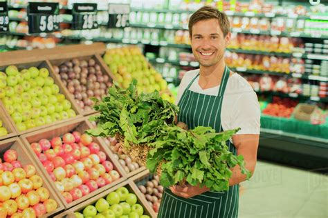 Clerk carrying produce in grocery store - Stock Photo - Dissolve