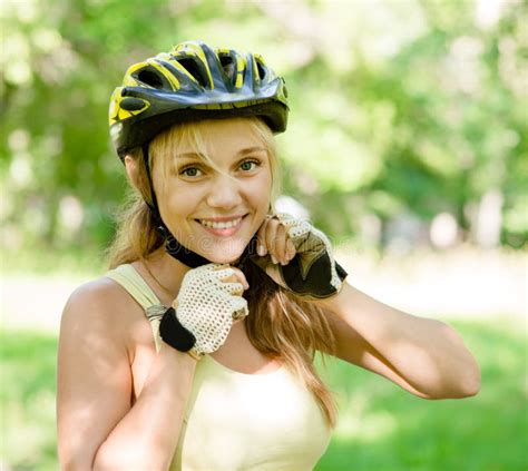 Woman Putting Biking Helmet On Outside During Bicycle Ride Stock Photo
