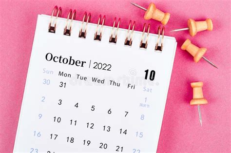 October 2022 Desk Calendar With Wooden Pin On Pink Background Stock