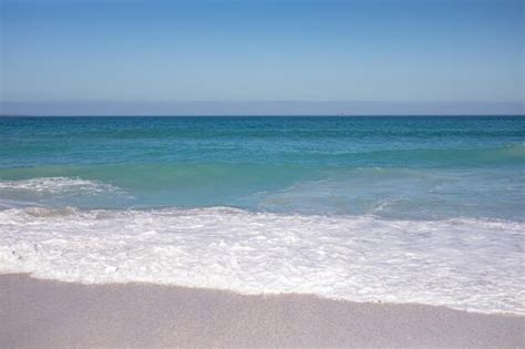 Premium Photo View Of A Sandy Beach And Calm Sea With Clear Blue Sky