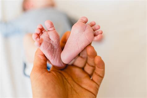 Newborn Feet Skinning Held By Mommy Stock Photo Download Image Now