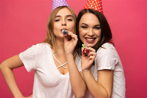 Close Up Portrait Of Blonde And Brunette Young Women With Birthday Hats Having Fun Isolated On