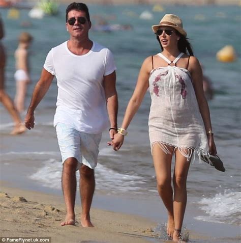 beaming simon shows he s a hands on father cowell grins broadly on romantic beach stroll with