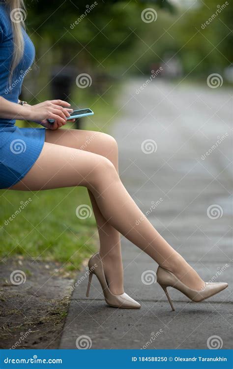 Woman With Perfect Legs In Pantyhose And High Heels And With Phone