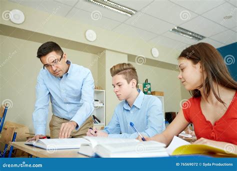 Teacher Helping Students With Task At School Stock Photo Image Of