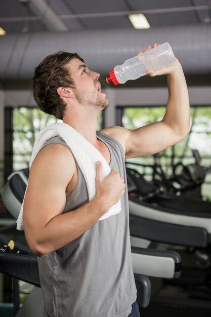 Premium Photo Man On Treadmill Drinking Water At Gym