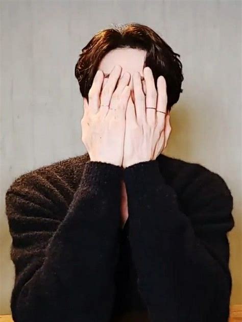 a man covering his face with both hands